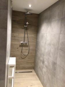 um chuveiro na casa de banho com uma parede de azulejos em Chez Odile em Offagne