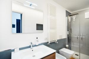 een badkamer met een wastafel, een toilet en een spiegel bij Duomo B&B in Teramo