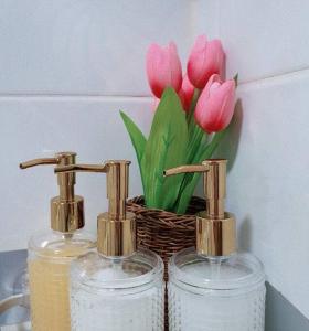 two glass bottles and a basket of pink tulips at 숙소 운영 휴무중 in Cheonan