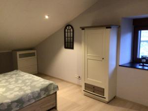 1 dormitorio en el ático con cama y ventana en Chez Odile, en Offagne