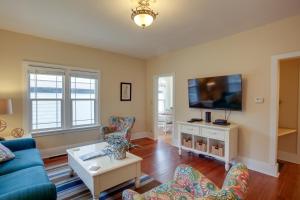 a living room with a blue couch and a tv at Downtown Coeur dAlene Retreat Near Lake and Parks! in Coeur d'Alene
