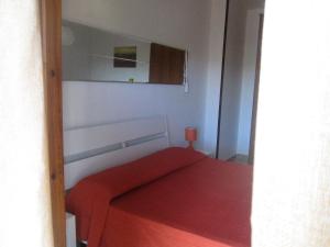 a bedroom with a red bed and a mirror at Casa Velina in Castelnuovo Cilento