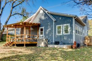 une maison bleue avec une terrasse couverte et une terrasse dans l'établissement Fayetteville Home 1 Mi to University of Arkansas!, à Fayetteville