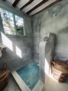 a bathroom with a shower in a room at Mawingu lodge in Kizimkazi
