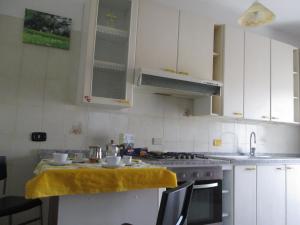 a kitchen with white cabinets and a yellow towel on the counter at Casa Velina in Castelnuovo Cilento