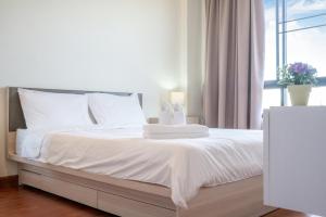 Ban SuanにあるThe Lago Apartmentsの白いベッド(白いシーツ、タオル付) +4枚の写真