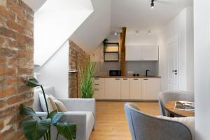 a kitchen and living room with a brick wall at Elite Apartments Old Town Długi Targ in Gdańsk
