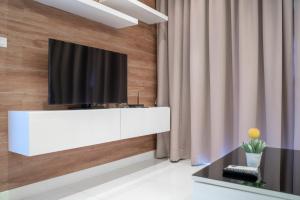 Ban SuanにあるThe Lago Apartmentsの白いキャビネットの上にテレビが置かれたリビングルーム