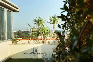 a view of a building with palm trees in the background at Penthouse Station Luxury Suites & Apartment in Brindisi