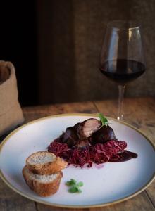 un piatto di cibo e un bicchiere di vino di Hotel & Restaurant Casolare Le Terre Rosse a San Gimignano