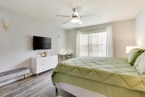 Un dormitorio con una cama y un televisor de pantalla plana. en Kissimmee Condo with Perks 6 Mi to Disney World!, en Kissimmee 21 fotos más