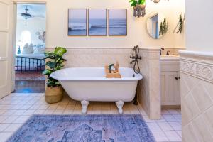 a bathroom with a white tub and a sink at Ocean View Spanish Beauty Half Block to Beach in San Diego