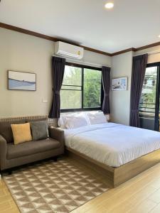 una camera con letto, divano e finestre di Kata Noi Place floor3 a Kata Beach