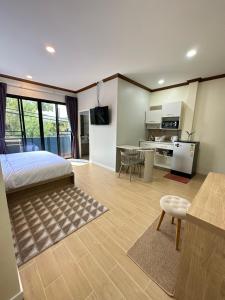 a bedroom with a bed and a kitchen and a table at Kata Noi Place floor3 in Kata Beach