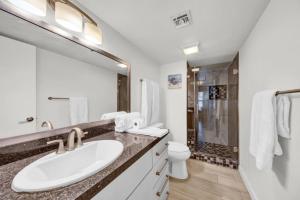 a white bathroom with a sink and a shower at Saida I Ground Floor Beach front in South Padre Island +18 photos