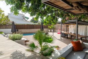 a patio with a table and chairs and a pool at Casa Guindilla in Portals Nous