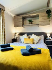 a large yellow bed with two blue towels on it at Adelfas in Scarborough