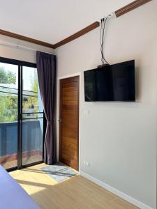 a bedroom with a flat screen tv on the wall at Kata Noi Place floor3 in Kata Beach