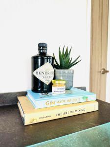 a stack of books sitting on a table with a plant at Adelfas in Scarborough