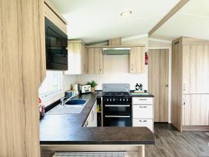 uma cozinha com armários de madeira e um forno com placa de fogão em Adelfas em Scarborough