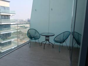 a balcony with three chairs and a table and a window at Yas Getaway in Abu Dhabi