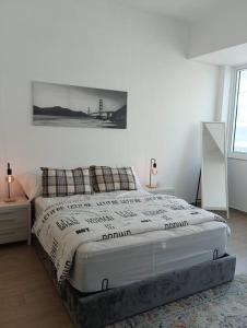 a white bedroom with a bed and a picture on the wall at Yas Getaway in Abu Dhabi