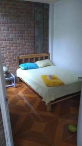sypialnia z łóżkiem i ceglaną ścianą w obiekcie Casa amoblada con cochera w mieście Ica