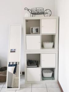 a white shelf with a mirror in a room at Room in shared apartment, near Lecco in Calolziocorte