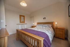 a bedroom with a large bed and a wooden bench at A 3 bed cottage in Exmoor with fantastic sea views in Lynmouth
