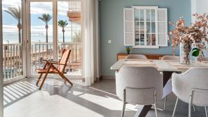 a dining room with a table and chairs and a balcony at Sohosuites Campello Beach in El Campello