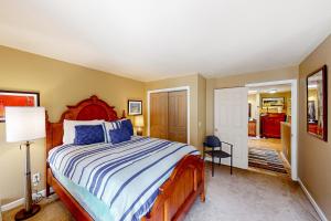 a bedroom with a bed with a blue and white comforter at SunRiver Mountain Getaway in Avon +13 photos