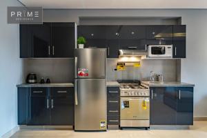 a kitchen with stainless steel appliances and black cabinets at Prime Residence New Cairo in Cairo