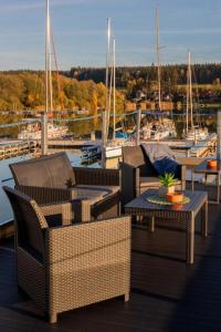 a group of chairs and tables on a dock with boats at Hausboat David in Hrdoňov