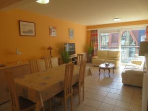 a kitchen and living room with a table and a couch at La perle du Nord in Middelkerke
