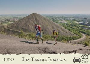 dos personas caminando sobre una pirámide en La Plume d'Or - Wifi - Parking Privé, en Lens