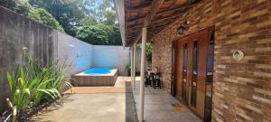 a house with a hot tub and a patio at Casinha da Vovó in São Lourenço