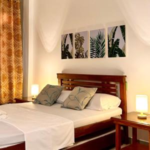 ein Schlafzimmer mit einem Bett mit zwei Tischen und zwei Lampen in der Unterkunft JORA Studio Apartment 1-C in Dagupan