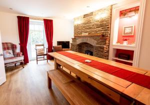 a living room with a table and a fireplace at Rhos y Gadair - an incredible farmhouse by the sea in Aberporth