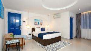 Habitación de hotel con cama y silla en Lucia Beach Hotel, en Da Nang