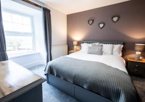 a bedroom with a bed with hearts on the wall at Rhos y Gadair - an incredible farmhouse by the sea in Aberporth