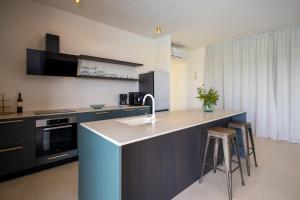 a kitchen with a sink and a counter with stools at Santa Lucia - Villa&Boat in Turanj