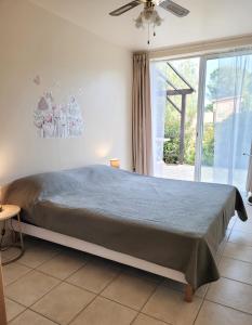 濱海阿熱萊斯的住宿－VILLA Élancia，一间卧室设有一张床和一个大窗户