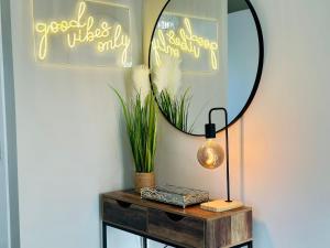 a table with a mirror and a lamp on it at Charming Studio Apartment in Milton Keynes with Free Parking & WiFi by HP Accommodation in Milton Keynes