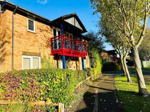a house with a red balcony on the side of it at Charming Studio Apartment with Free Parking & WiFi in Milton Keynes by HP Accommodation in Milton Keynes