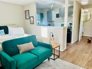 Charming Studio Apartment with Free Parking & WiFi in Milton Keynes by HP Accommodation في ميلتون كينز: غرفة معيشة مع أريكة زرقاء وسرير