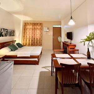 sypialnia z łóżkiem i stołem oraz jadalnia w obiekcie JORA Studio Apartment 1-C w mieście Dagupan
