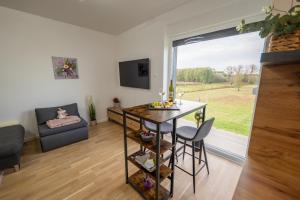 a living room with a table and chairs and a window at Apartman Nebo - Pogled na Stari Grad i Minizoo besplatne ulaznice - Free tickets in Ðurđevac