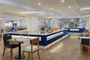a restaurant with blue counters and tables and chairs at H10 Vintage Salou - Adults Only in Salou