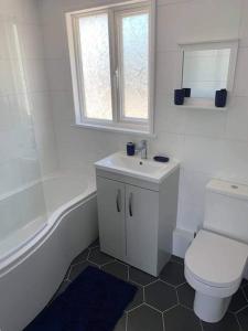 a bathroom with a toilet and a tub and a sink at Crud Yr Awel, Dinas, Pembrokeshire in Dinas