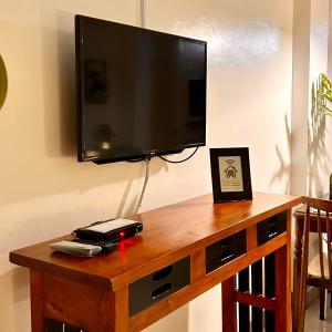a flat screen tv on top of a wooden table at JORA Studio Apartment 1-C in Dagupan